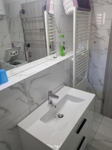a white bathroom with a sink and a mirror at Olive and Herb Retreat II in Valtura +10 photos