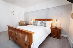 a bedroom with a large bed with white sheets and pillows at Cottage nr BikeParkWales/Brecon Beacons/PenYFan in Merthyr Tydfil
