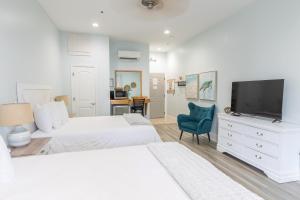 a bedroom with two beds and a flat screen tv at Hotel Whiskey in Pass Christian in Pass Christian