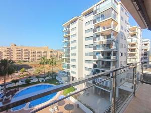 einen Balkon mit Blick auf ein Gebäude und einen Pool in der Unterkunft Ayf 200m del mar 2 piscinas, pista de padel y gym in Oropesa del Mar