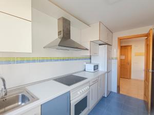eine Küche mit Spüle und Herd oberen Backofen in der Unterkunft Ayf 200m del mar 2 piscinas, pista de padel y gym in Oropesa del Mar