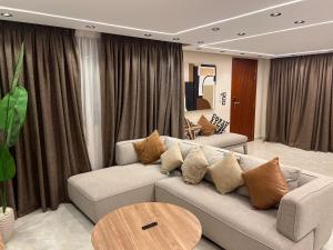 una sala de estar con un sofá y una mesa en MTMZ B - 3 BDR Apartment - By Kemetland, en Seis de Octubre