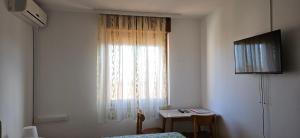a bedroom with a window with a table and a bed at Rooms Laguna Maresol in Jagodje