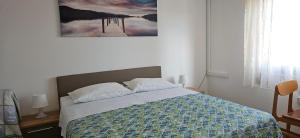 a bedroom with a bed with a painting on the wall at Rooms Laguna Maresol in Jagodje