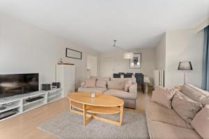 una sala de estar con un sofá y una mesa en Hotel Van Brugge D2, en De Haan 4 fotos más