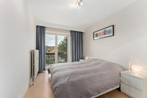 Un dormitorio blanco con una cama y una ventana. en Hotel Van Brugge D2, en De Haan