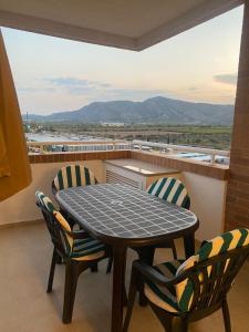 ein Tisch und Stühle auf einem Balkon mit Aussicht in der Unterkunft Apartamento con terraza, piscina y vistas en Oropesa del Mar Edificio Torremar in El Borseral