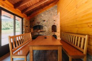 a wooden table and benches in a room with a fireplace at Kuća za odmor Roko in Sveti Rok +15 photos