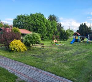 a yard with a park with a playground at Domek 4 osobowy in Stegna