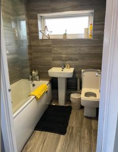 a bathroom with a tub and a sink and a toilet at Beautiful holiday home South Beach Blyth 3 minute walk to the beach in Newsham +7 photos