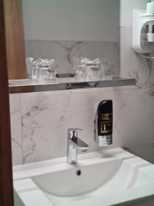 a bathroom sink with a soap dispenser on it at Hotel Adria in Kaštela +65 photos