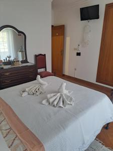 a bedroom with a bed with towels on it at Casa Barbara in Lagos +2 photos