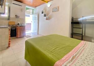 a bedroom with a green bed and a kitchen at Bentivegna Apartments in Syracuse