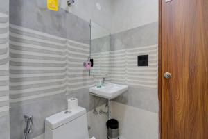 a white bathroom with a sink and a toilet at Aura Homes 1 BHK Serviced Apartment Near Golf Course Road Gurgaon in Gurgaon +30 photos