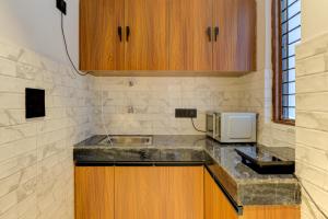 a kitchen with a sink and a microwave at Aura Homes 1 BHK Serviced Apartment Near Golf Course Road Gurgaon in Gurgaon