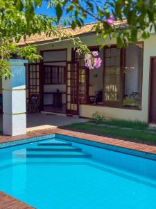 Pousada vila Riveira في بوزيوس: حمام سباحة أمام منزل