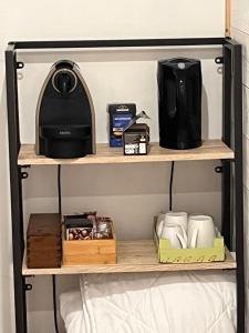 a coffee maker and other items on a shelf at Les Poules heureuses in Issoire