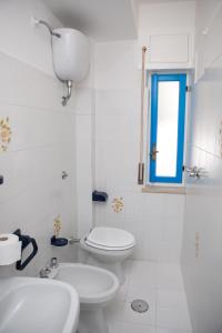 a bathroom with two sinks and a toilet and a window at Appartamento Stefano in Scalea +24 photos