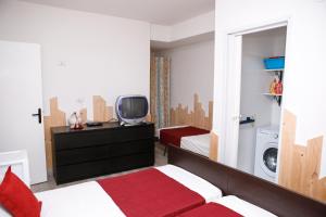 a bedroom with a bed and a tv and a washing machine at Appartamento Stefano in Scalea