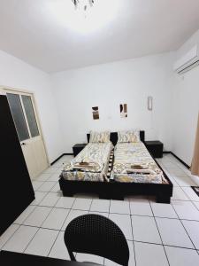a room with two beds and a chair in it at Lovely Paceville Studio G in St. Julianʼs