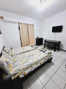 a bedroom with a bed and a desk and a television at Lovely Paceville Studio G in St. Julianʼs