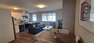 a living room with a blue couch and a table at Happy Zone Suite With AC- Sleeps 4 - Welcome Snacks & Drinks ! in Langford