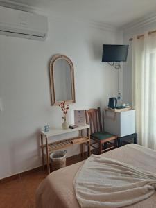 a bedroom with a bed and a desk and a mirror at Casa Barbara in Lagos