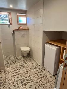 a small bathroom with a toilet and a tile floor at Les Poules heureuses in Issoire +12 photos