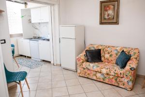 a living room with a couch and a kitchen at Appartamento LUX in Scalea