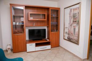 a living room with a entertainment center with a flat screen tv at Appartamento LUX in Scalea