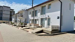 a group of buildings with benches in a courtyard at Vila Plaja Azur in Eforie Nord