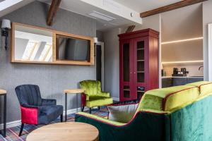 a room with chairs and a tv and a bed at Willa Miłosna in Kwidzyn