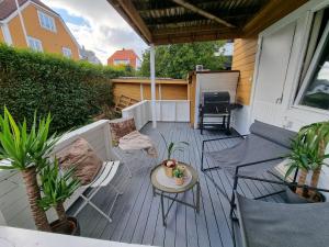 un patio avec des chaises, une table et un grill dans l'établissement Spacious and central apartment with a private garden, Free parking and Free EV recharging, à Stavanger
