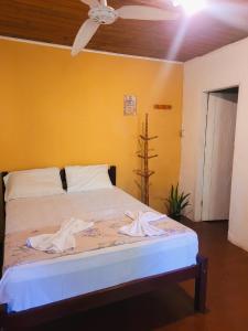 a bedroom with a bed with towels on it at Pousada Alto Mar, hostel e camping in Arraial d'Ajuda