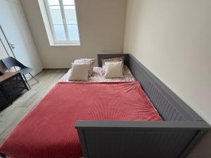 a bedroom with a large bed with a red blanket at Les Paddocks du Damier Manceau in Marigné-Laillé