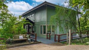 a green house with a porch and a wooden deck at Mountain Retreat Ruby's Roost House in Mentone