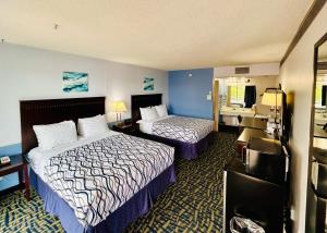 a hotel room with two beds and a bathroom at Hospitality Inn in North Platte
