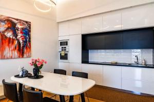 a kitchen with a white table with chairs and a painting at On The Hill in Mytilene