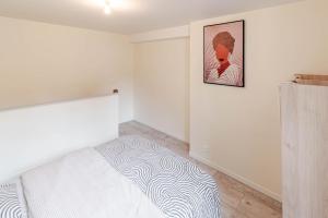 a bedroom with a bed and a picture on the wall at Appartement F2 centre ville in Auxerre