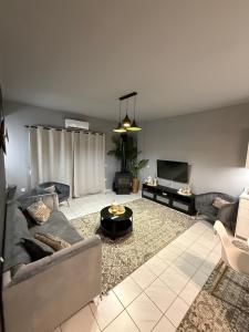 a living room with a couch and a tv at RHODESIA guest house in Chalkida