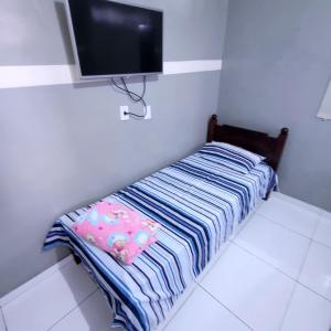 a bed in a room with a flat screen tv at Pousada guarany acesso aos quartos apenas por escadas in Campina Grande