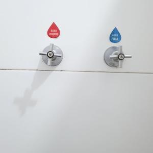 a pair of bathroom hooks on a white wall at Pousada guarany acesso aos quartos apenas por escadas in Campina Grande