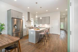 a kitchen with white cabinets and stainless steel appliances at Double Time - Ping-Pong Table - Mins to Germantown in Nashville