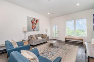 a living room with two blue chairs and a couch at Double Time - Ping-Pong Table - Mins to Germantown in Nashville