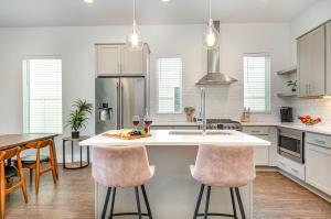 a kitchen with white cabinets and a kitchen island with bar stools at Double Time - Ping-Pong Table - Mins to Germantown in Nashville