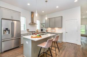a kitchen with a refrigerator and two bar stools at Double Time - Ping-Pong Table - Mins to Germantown in Nashville
