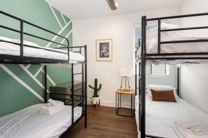 two bunk beds in a room with green walls at Double Time - Ping-Pong Table - Mins to Germantown in Nashville