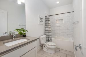 a white bathroom with a toilet and a sink at Double Time - Ping-Pong Table - Mins to Germantown in Nashville