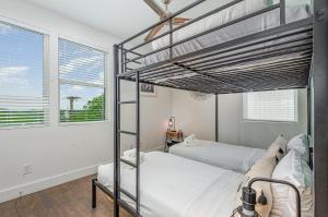 a bedroom with two bunk beds and two windows at Double Time - Ping-Pong Table - Mins to Germantown in Nashville
