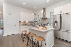a kitchen with white cabinets and a kitchen island with stools at Double Time - Ping-Pong Table - Mins to Germantown in Nashville